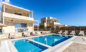 a villa with a swimming pool and a patio at Villa Thea in Triopetra