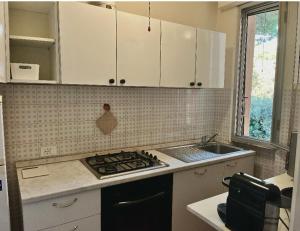 a kitchen with white cabinets and a stove top oven at Casa del Sole in Versilia in Cinquale