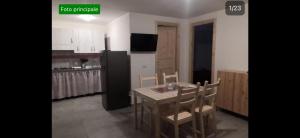 a kitchen with a table and chairs and a black refrigerator at Residence la Duna in Castel Volturno