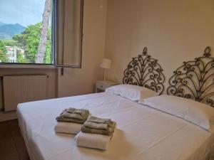 a bedroom with two towels on a bed with a window at Casa del Sole in Versilia in Cinquale