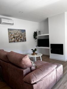 a living room with a brown couch and a tv at Tía Pepa in El Gastor