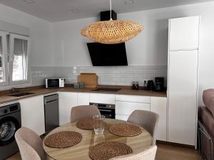 a kitchen with a table with chairs and a chandelier at Tía Pepa in El Gastor