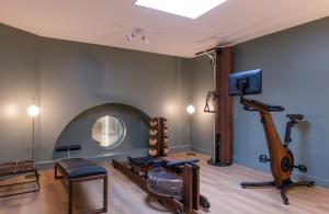 ein Raum mit einem Fitnessstudio mit Laufband und Spiegel in der Unterkunft Leonardo Boutique Hotel Paris Opera in Paris