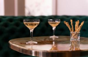 Zwei Gläser Champagner stehen auf einem Tisch. in der Unterkunft Leonardo Boutique Hotel Paris Opera in Paris