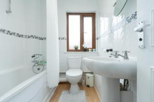 a white bathroom with a toilet and a sink at Open Mind Property - 3BR with Free Parking & Garden in Portsmouth