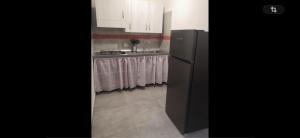 a kitchen with a black refrigerator and a sink at Residence la Duna in Castel Volturno