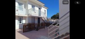 a white house with a gate and a staircase at Residence la Duna in Castel Volturno +3 photos