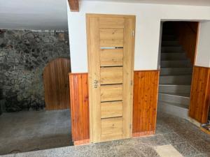 a wooden door in a room with stairs at Apartment sklep 33E in Hrušky
