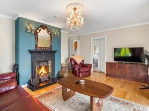 a living room with a couch and a fireplace at Connemara Bay House in Moyard