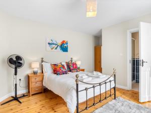 a bedroom with a bed and a fan at Connemara Bay House in Moyard