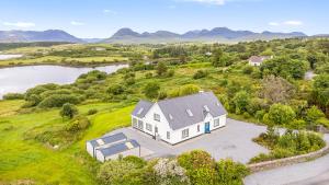 an aerial view of a white house on a hill next to a river at Connemara Bay House in Moyard