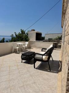a patio with two chairs and a table on a roof at Studio Apartment Rose in Selca +17 photos