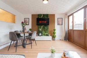 a living room with a table and chairs at Open Mind Property - 3BR with Free Parking & Garden in Portsmouth