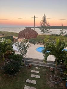 a resort with a straw umbrella and a swimming pool at Pousada In Paradiso in Santa Cruz