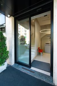 a glass door of a house with a red chair at Hotel Nuovo Metrò in Milan