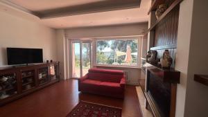 a living room with a red couch and a large window at Brezza sul Colle in Montesilvano