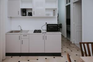 a white kitchen with a sink and a stove at VILLA Lafayette in Tunis
