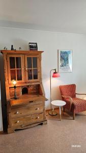 a living room with a wooden cabinet and a chair at Stavanger Urban Folkehøyskole in Stavanger +39 photos