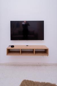 a flat screen tv sitting on top of a wooden entertainment center at VILLA Lafayette in Tunis