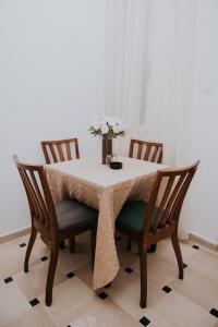 a dining room table with a white table cloth and chairs at VILLA Lafayette in Tunis +6 photos