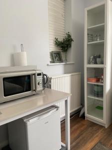 a microwave sitting on a counter in a kitchen at Spacious Double Studio-style room in Orpington +11 photos