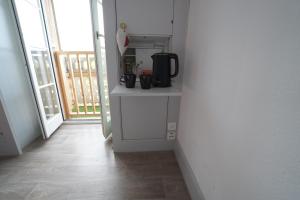 a hallway with a kitchen with a coffee maker on a counter at Hotel Du Lac in Därligen