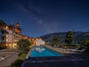 a villa with a swimming pool at night at Hotel Du Lac in Därligen