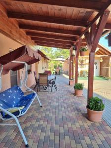 a patio with a blue chair under a wooden pergola at Horváth kuckó in Fonyód