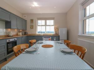 a kitchen with a table with plates and wine glasses at Keepers Cottage in Haddington