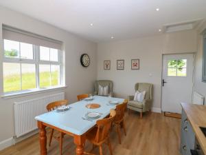 a dining room with a blue table and chairs at Keepers Cottage in Haddington +16 photos
