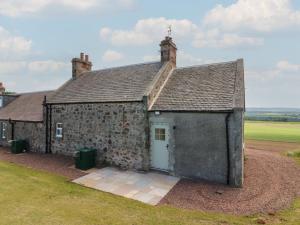 an old stone building with a blue door at Keepers Cottage in Haddington