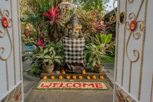 an entrance to a garden with a statue behind a gate at Pondok Alami Villas 5BR & Pool in Ubud +22 photos