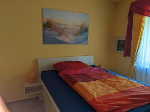 ein Schlafzimmer mit einem Bett und einem Gemälde an der Wand in der Unterkunft Renova13 in Süderbrarup