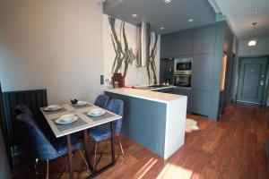 a kitchen with blue cabinets and a table with chairs at Benesta Residence by NewInn in Istanbul +122 photos