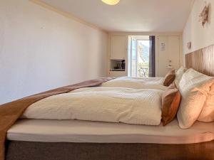 a bedroom with two beds and a window at Hotel Du Lac in Därligen