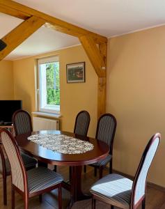 a dining room with a wooden table and chairs at Sodyba Miegėnuose in Miegėnai