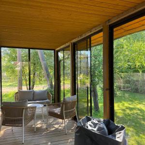 a screened in porch with a table and chairs at Sodyba Miegėnuose in Miegėnai