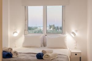 a bedroom with two towels on a bed with a window at NEP APT Gennadi in Gennadi