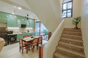 a kitchen and dining room with a table and a staircase at Tiadoro Villa in Calangute