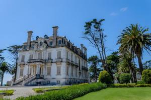 an old house with palm trees in front of it at Casa do Mar na Figueira da Foz in Figueira da Foz