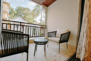 a balcony with a chair and a table and a window at Tiadoro Villa in Calangute