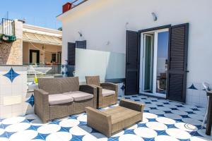 a patio with wicker chairs and a table at Agriresort La Dragonara in Bacoli