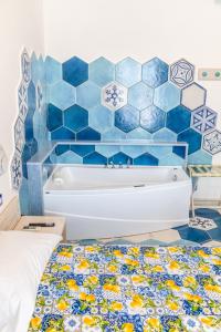 a blue tiled wall with a tub in a bedroom at Agriresort La Dragonara in Bacoli