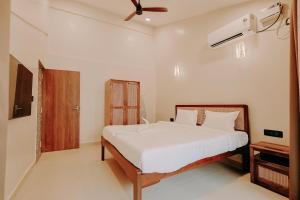 a bedroom with a bed and a ceiling fan at Tiadoro Villa in Calangute +8 photos
