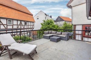 a balcony with a couch and chairs on a building at Jolie Appartement Bei Kassel in Eiterhagen