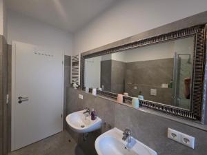 a bathroom with two sinks and a large mirror at Apartment am Saaleradwanderweg in Merseburg +7 photos