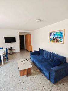 a living room with a blue couch and a coffee table at Apartmani Radovic in Bijela
