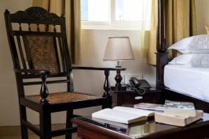 a bedroom with a chair and a desk with a phone at Resort Coqueiral - A Portuguese Heritage Stay by the Sea in Candolim +22 photos