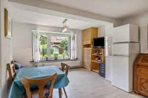 a kitchen with a table and a refrigerator at Jolie Appartement Bei Kassel in Eiterhagen +8 photos
