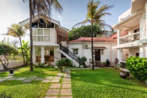 a courtyard of a house with palm trees at Resort Coqueiral - A Portuguese Heritage Stay by the Sea in Candolim